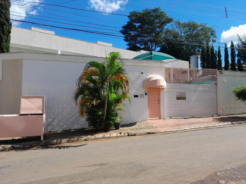 un edificio blanco con una palmera al lado de una calle en Flats Santa Genoveva, en Goiânia