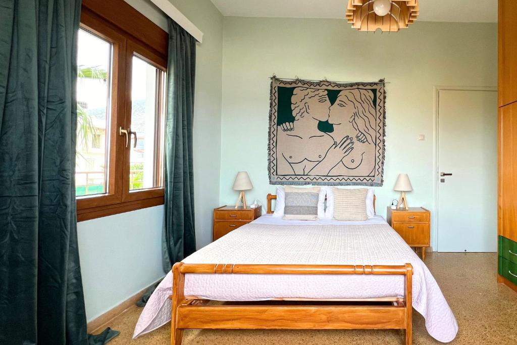 a bedroom with a bed and a picture on the wall at 4BR Newly Renovated Retreat Tranquil Coastal Haven in Hersonissos