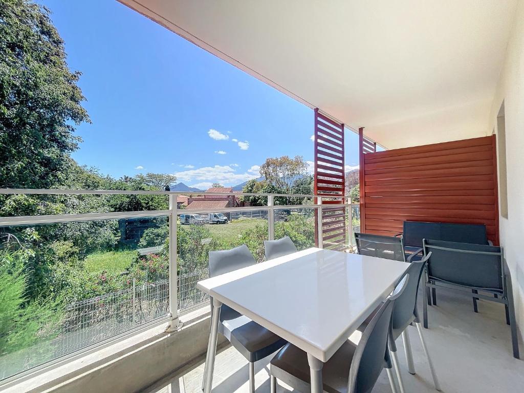 une salle à manger avec une table et des chaises blanches ainsi qu'une grande fenêtre dans l'établissement 3617-Appartement 4 couchages avec piscine, à Argelès-sur-Mer