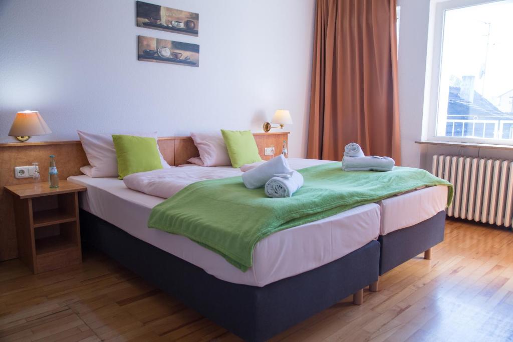 a bedroom with a bed with two stuffed animals on it at Hotel Eschborner Hof in Frankfurt