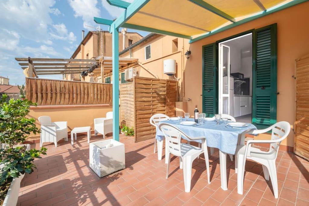 a patio with a table and chairs on a balcony at Terrazza nel Corso-City center in Piombino