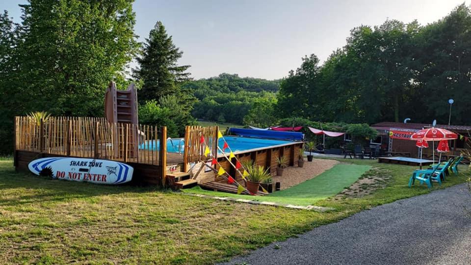 een park met een speeltuin met een glijbaan en een speelplaats bij CAMPING LA PERLE in La Rochette