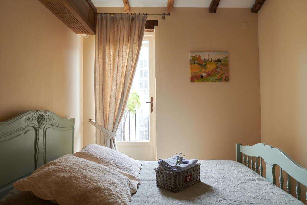 um quarto com uma cama e uma janela em Un Mas en Ville em Marselha