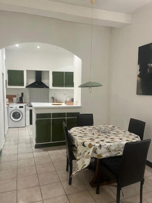 une cuisine avec une table et des placards verts dans l'établissement Centrale - Grand T2 Bis proche de la mer, à Nice