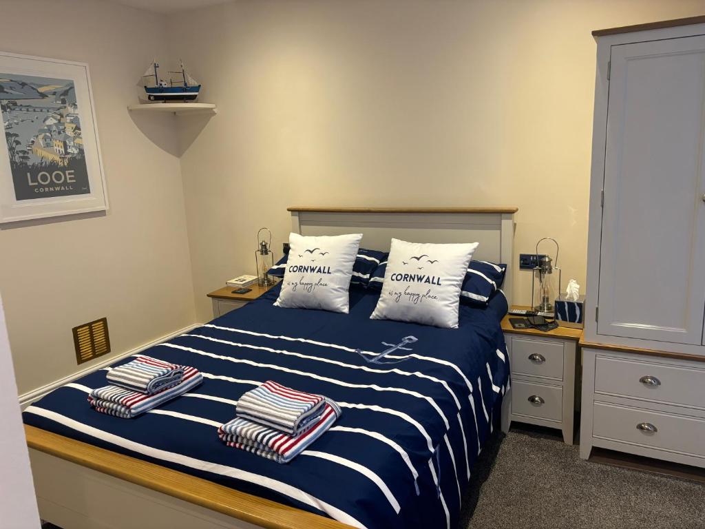 a bedroom with a blue and white bed with pillows at Seagull Cottage in Looe