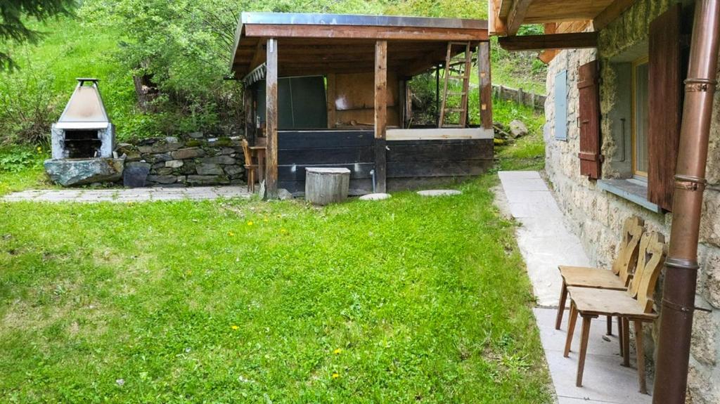 a yard with a fireplace and a bench next to a house at Chalet a Didi - Alps Paradise - 4 Vallees in La Tzoumaz