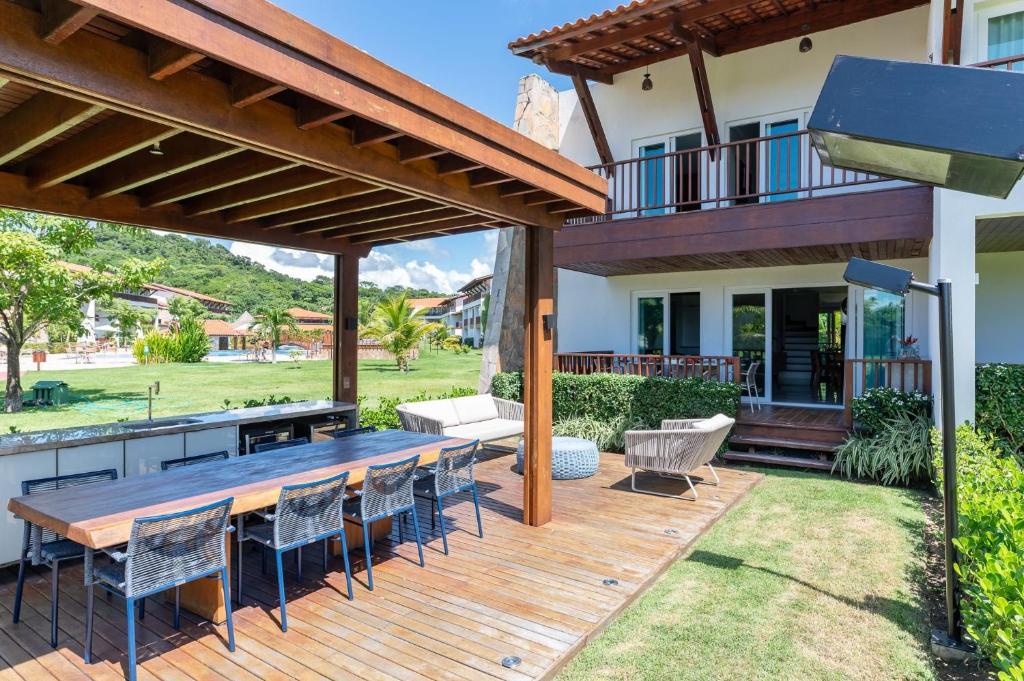 un patio avec une table et des chaises en bois dans l'établissement Bela Casa No Meridional-Serv de Limpeza-SH091, à Tamandaré
