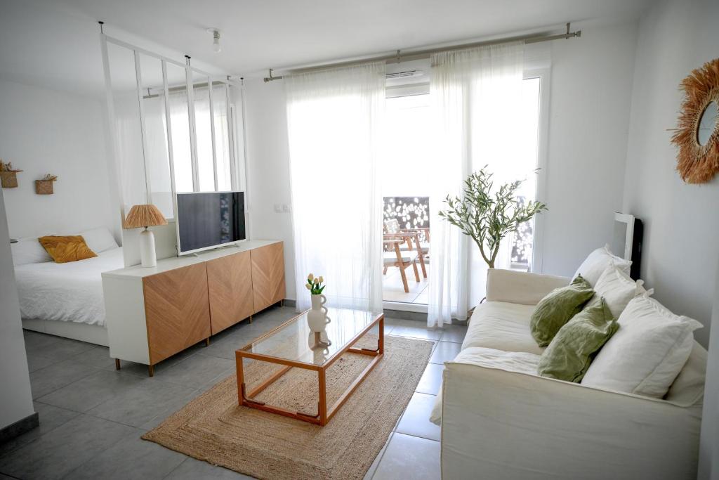 salon z białą kanapą i telewizorem w obiekcie Appartement terrasse proche Centre w Montpellier