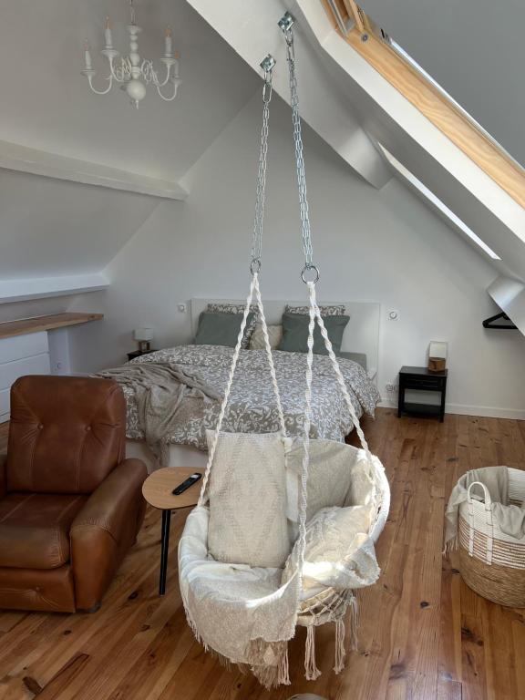 a swing in a room with a bed and a couch at Escapade en Baiocensis in Villiers-le-Sec