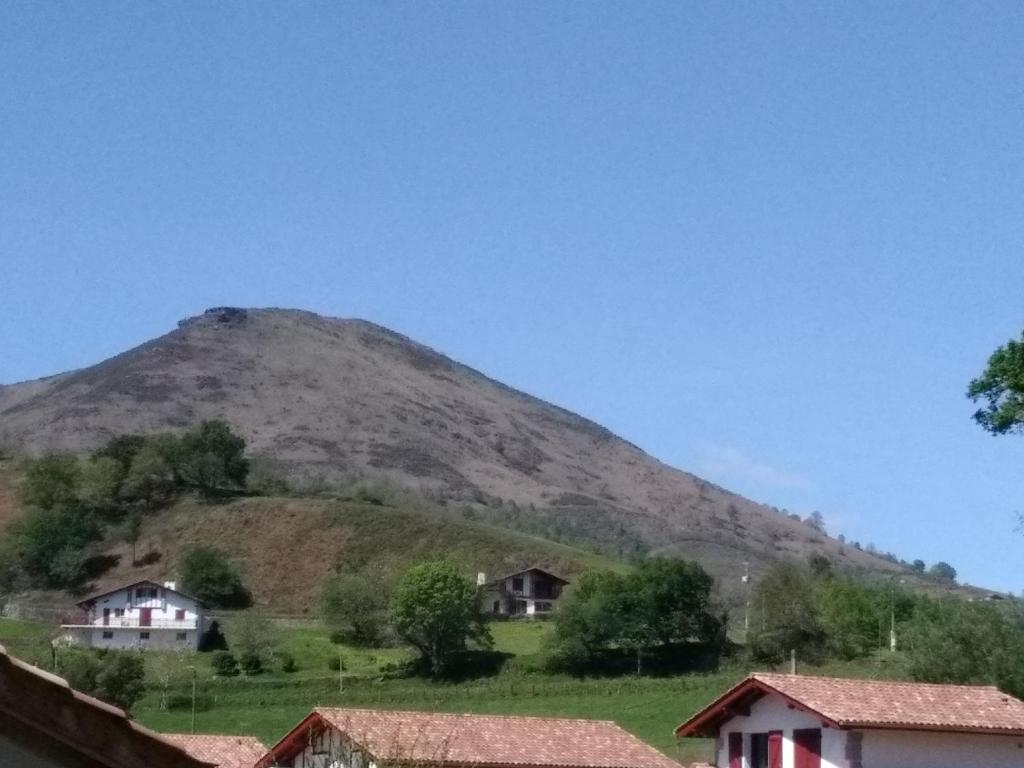 a mountain in the distance with houses in the foreground at Bizi logela in Bidarray