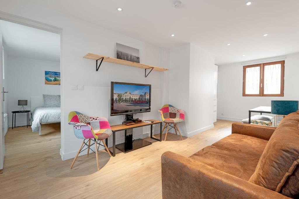 un salon avec un canapé et une table avec des chaises dans l'établissement Le Gorille hypercentre et climatisation, à Toulouse