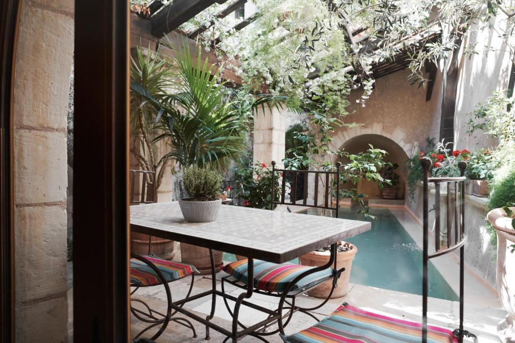 a patio with a table and potted plants at Un Mas en Ville in Marseille