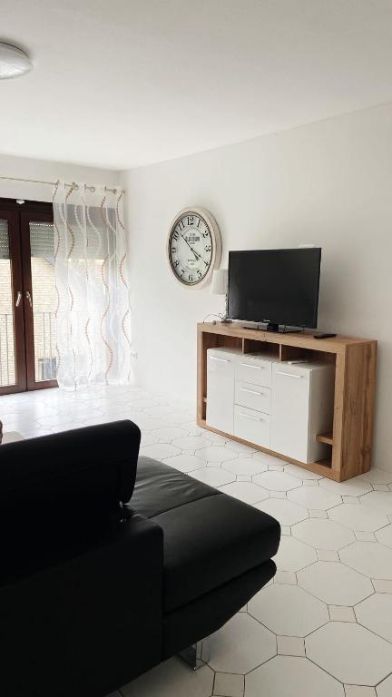 a living room with a couch and a clock on the wall at IIA Apartments in Warzen