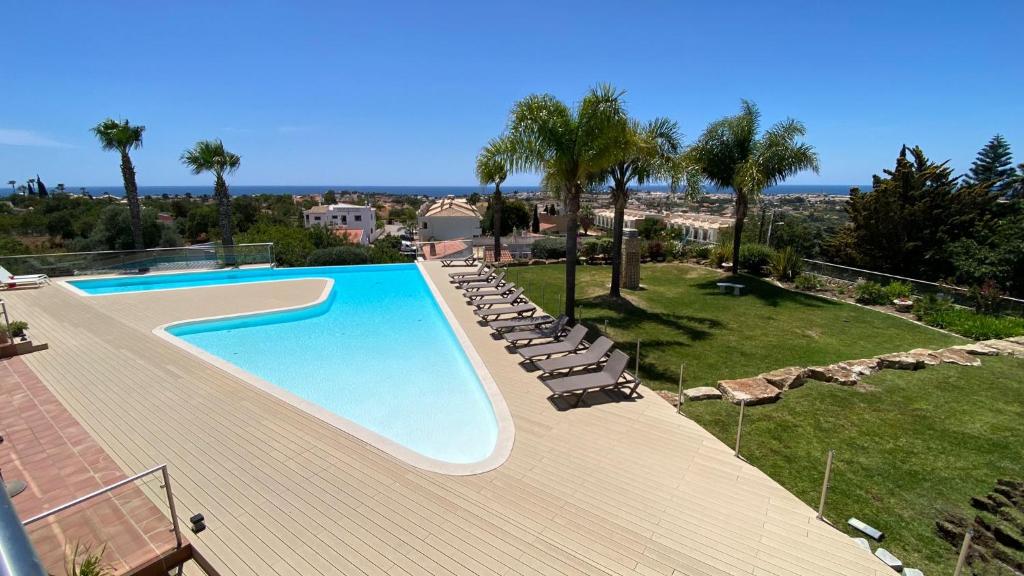 une piscine sur le toit avec des chaises et des arbres dans l'établissement Luxury Villa Albufeira, à Albufeira