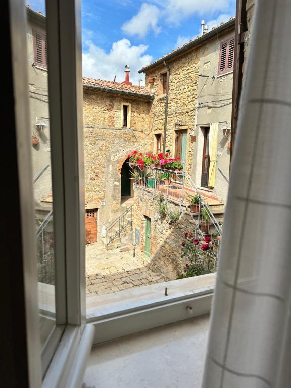 een raam met uitzicht op een steegje bij 81Passi in Casale Marittimo