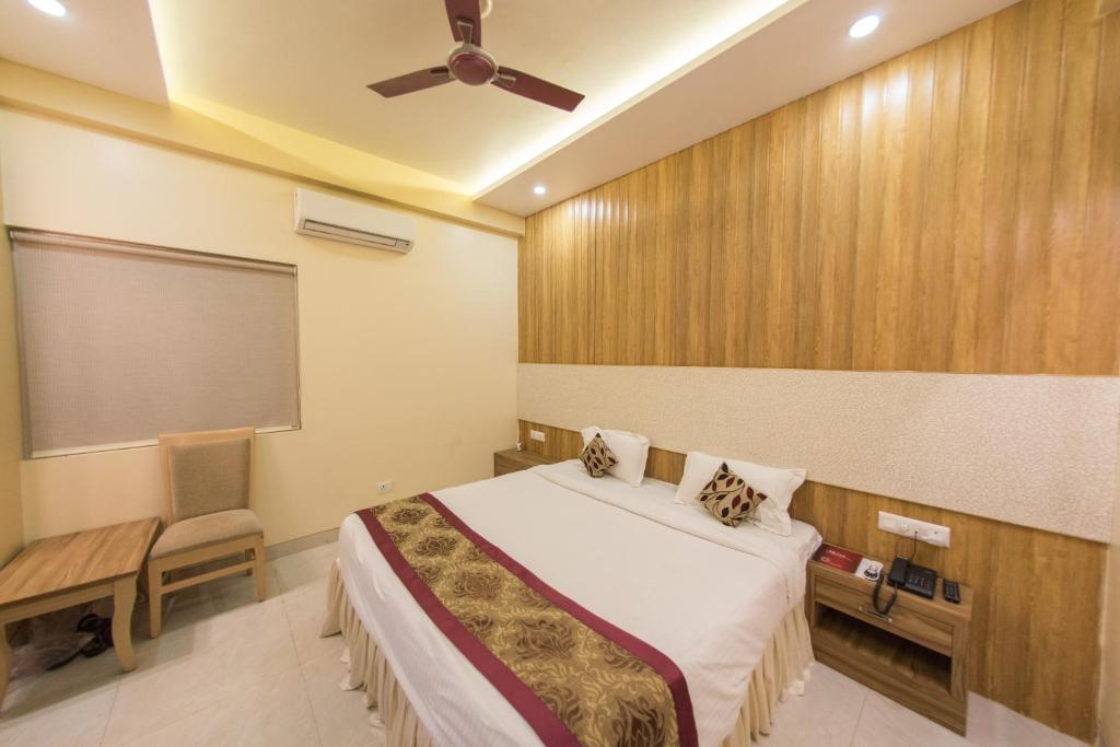 a bedroom with a bed and a ceiling fan at Hotel Ratana International in Lucknow