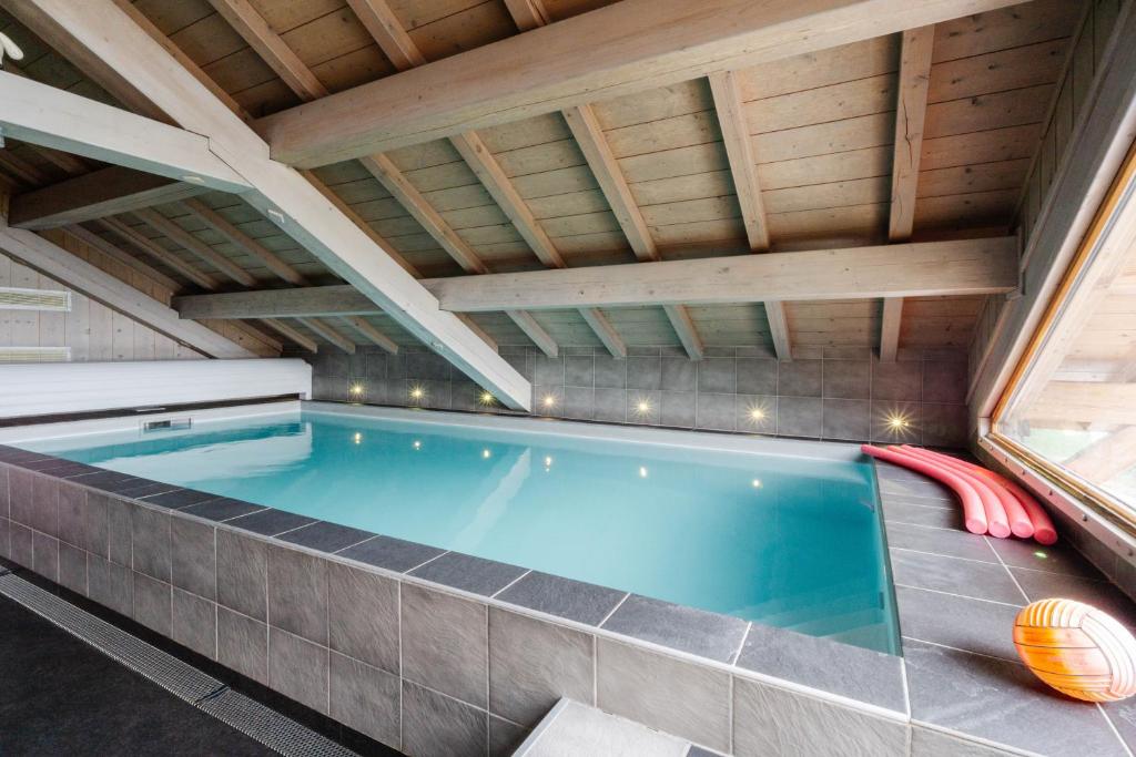 a swimming pool in a house with a roof at Chalet le jardin d'hiver in La Toussuire