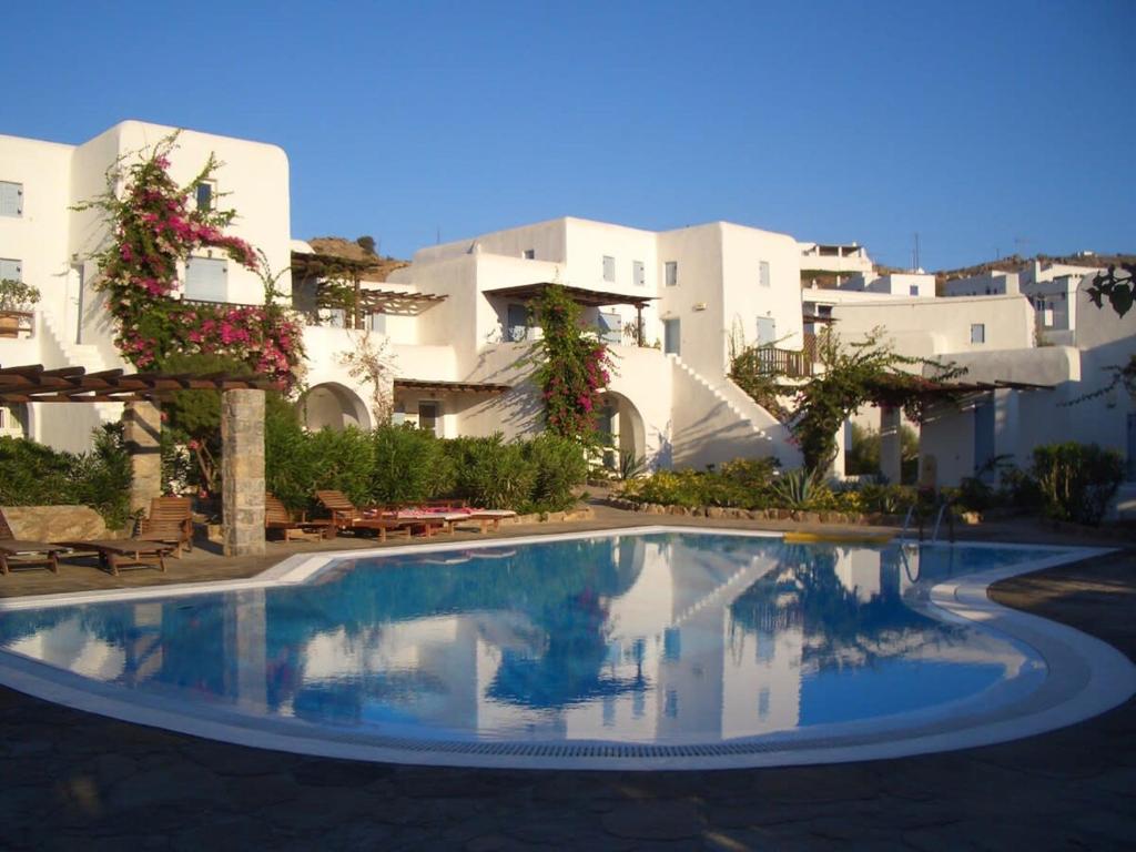 a swimming pool in front of some white buildings at Pleiades Modern Villa with Shared Pool in Ornos in Ornos