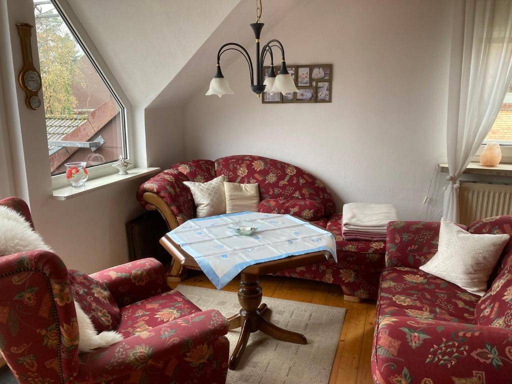 Ferienwohnung Heideweg في شنيفردينغين: غرفة معيشة مع كرسيين وطاولة