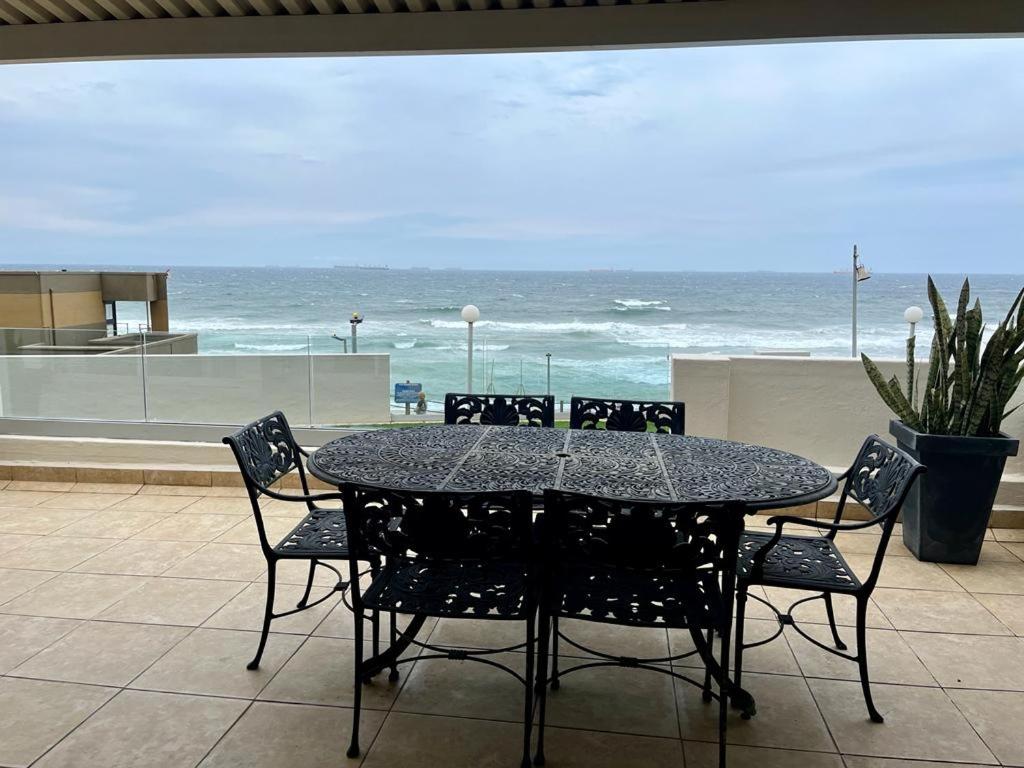 a table and chairs with a view of the ocean at 204 Marbella Umhlanga in Durban