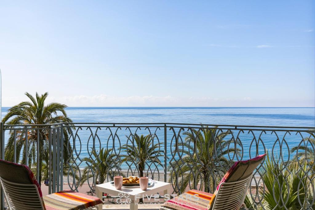 une table et des chaises sur un balcon donnant sur l'océan dans l'établissement Suite Grand Sud FSHH, à Nice