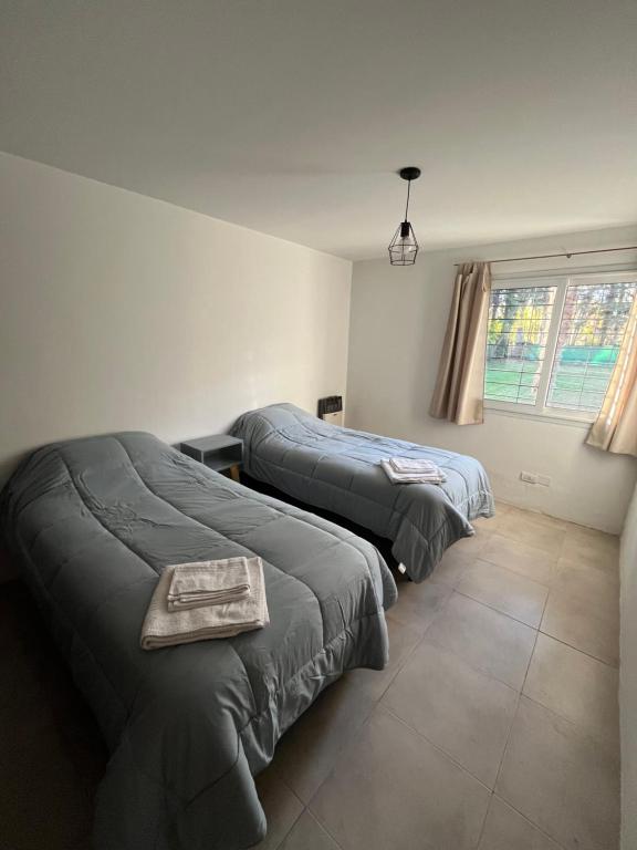 una camera da letto con due letti e una finestra di Casa Los Ciruelos - Chacras de Coria a Mayor Drumond