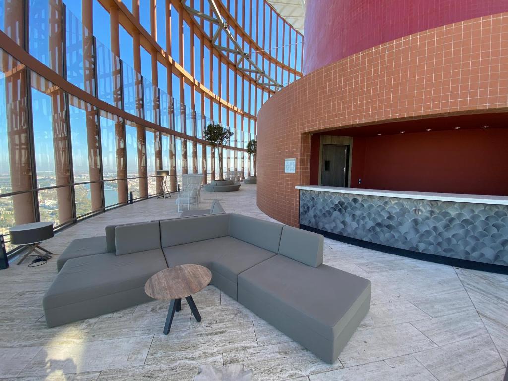 a lobby with a couch and a table in a building at Eurostars Torre Sevilla in Seville