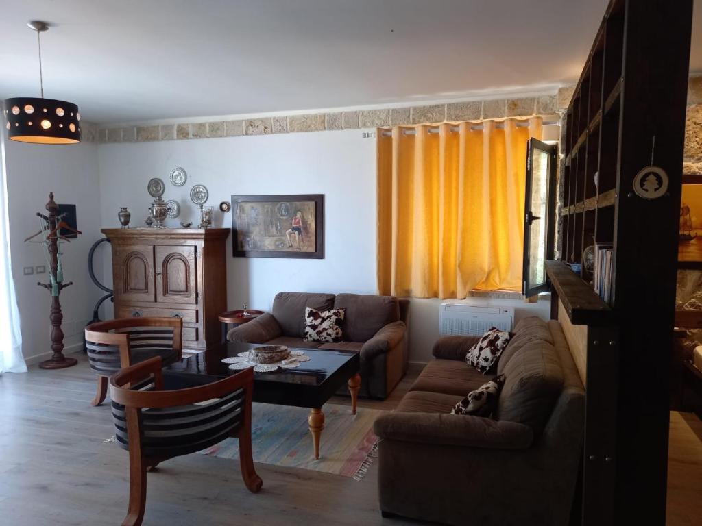 a living room with a couch and a table at Rahoni Park & Suites in Dhërmi