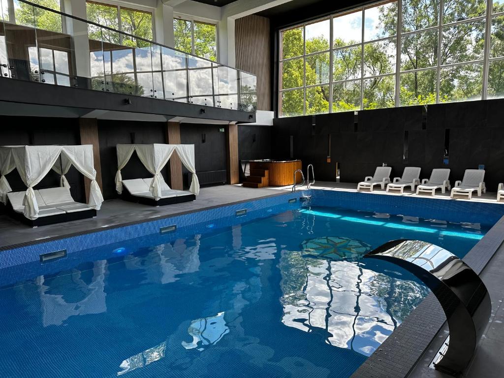 einen großen Pool mit Stühlen und einem Pool in der Unterkunft WRZOS resort & wellness in Węgierska Górka