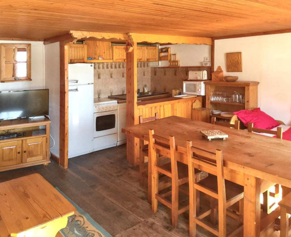 アルヴィユーにあるAppartement de 2 chambres a Arvieux a 800 m des pistes avec balcon amenage et wifiのキッチン(木製テーブル、白い冷蔵庫付)