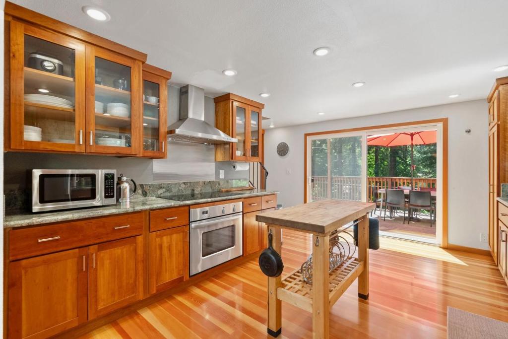 a kitchen with wooden cabinets and a wooden table at Redwood Oasis - Eco-luxury cabin with hot tub in the Santa Cruz Mountains in Ben Lomond