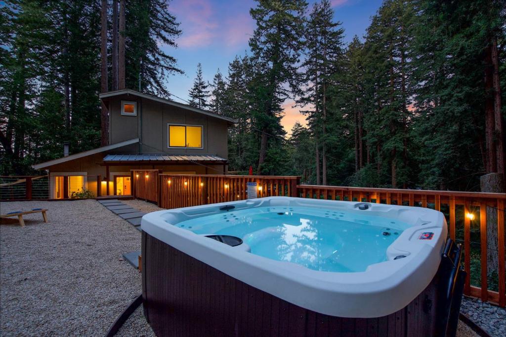 a jacuzzi tub in the yard of a house at Redwood Oasis - Eco-luxury cabin with hot tub in the Santa Cruz Mountains in Ben Lomond