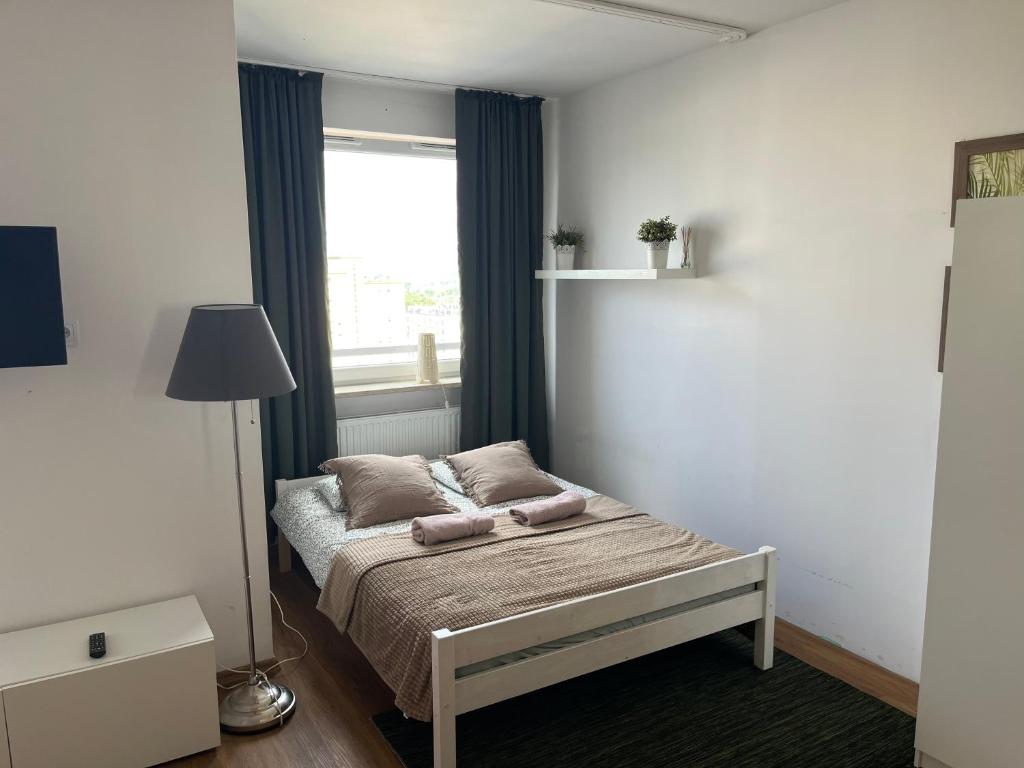 a small bedroom with a bed with a window at Apartament Modlińska in Warsaw