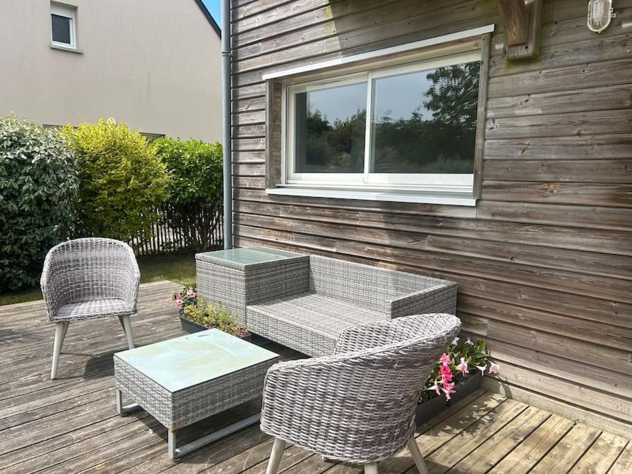 a patio with two chairs and a bench and a table at L escapade du Cap in Barneville-Carteret