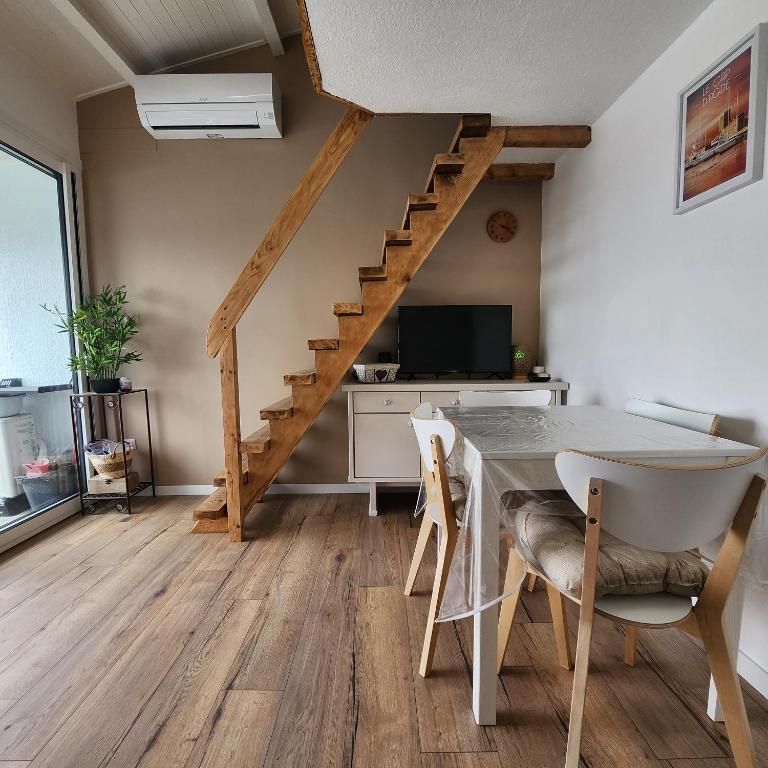 a living room with a table and a staircase at Studio cabine 4 pers vue mer in Cap d'Agde