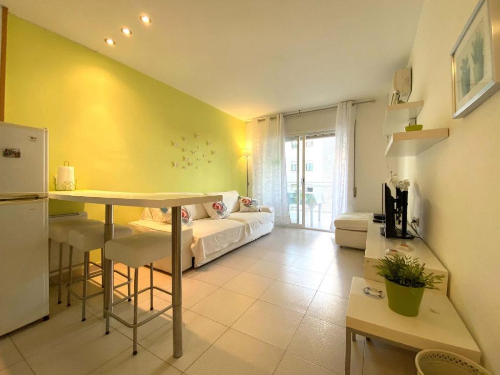 Una cocina y una sala de estar con una mesa y un sofá. en Cambrils PORT 11003, en Cambrils