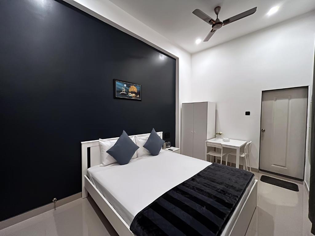 a bedroom with a large bed with a black wall at KIANA STAYS in Alībāg