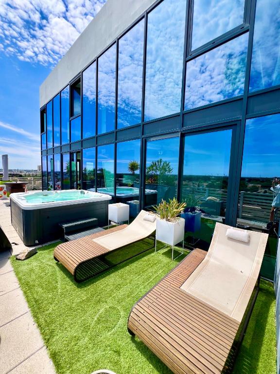 un grand bâtiment avec une piscine et un bâtiment avec des fenêtres dans l'établissement Luxueux et unique Penthouse en Rooftop à Montpellier, à Montpellier