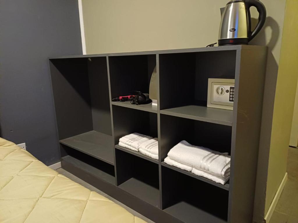 a black book shelf with towels in a room at Anchorena 1117 Hotel Suite And Hostel in Buenos Aires