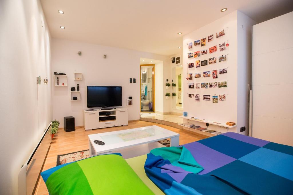 ein Wohnzimmer mit einem Sofa und einem TV in der Unterkunft eazZynight Center Apartment in Zagreb