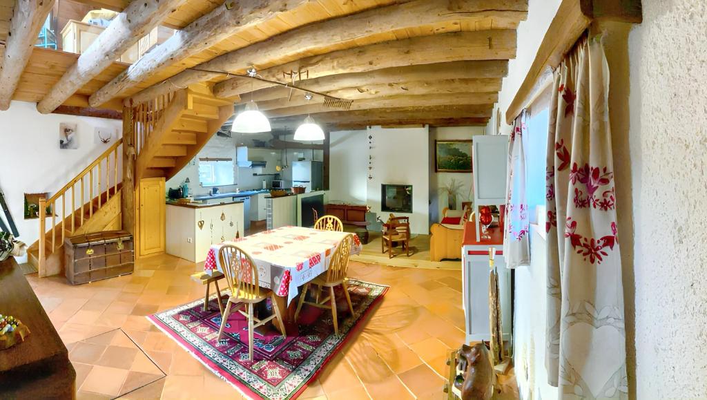 ein Wohnzimmer mit einem Tisch und einer Küche in der Unterkunft Maison d'une chambre avec terrasse amenagee a Mont a 3 km des pistes in Mont