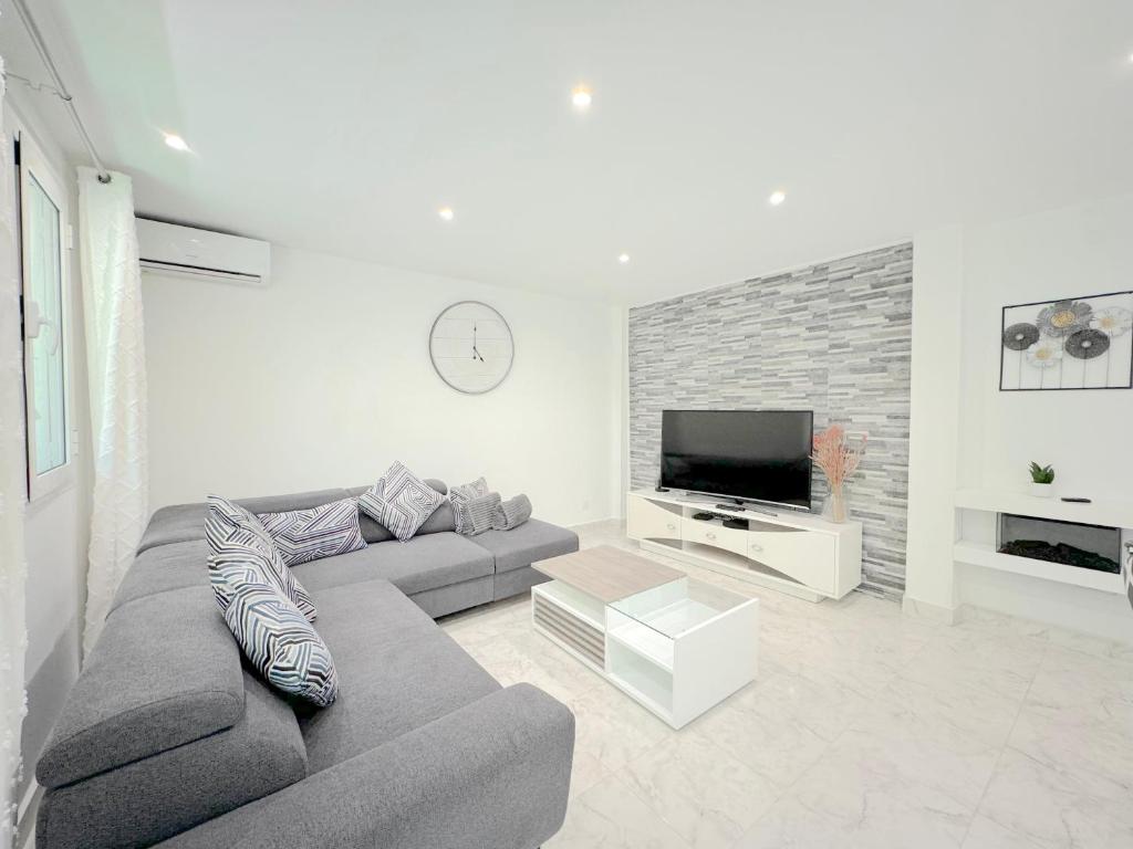 un salon avec un canapé et une télévision à écran plat dans l'établissement Beau 3P à 4 min des plages centre Juan Les Pins, à Antibes