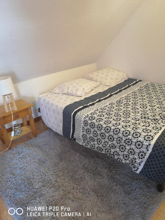 une chambre avec un lit avec une couette noire et blanche dans l'établissement Studio entier, à Sens