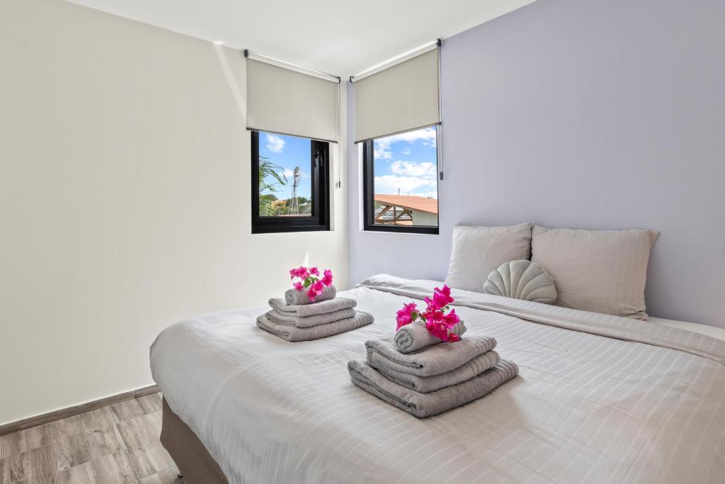 une chambre avec un lit blanc avec des serviettes dessus dans l'établissement Malvales Resort, à Willemstad