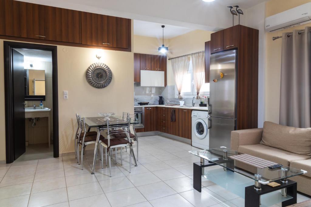 a kitchen and living room with a couch and a table at Windmill 23 Apartment in Agios Nikolaos