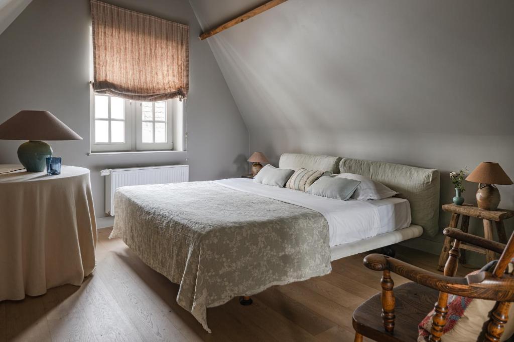 a bedroom with a bed and a table and a window at Guesthouse Aubrey - Charming Cottage in the Heart of Bruges in Bruges