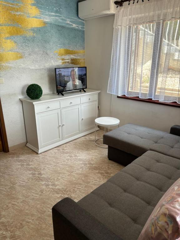 salon z kanapą i telewizorem z płaskim ekranem w obiekcie Apartment Jasna B w mieście Omišalj