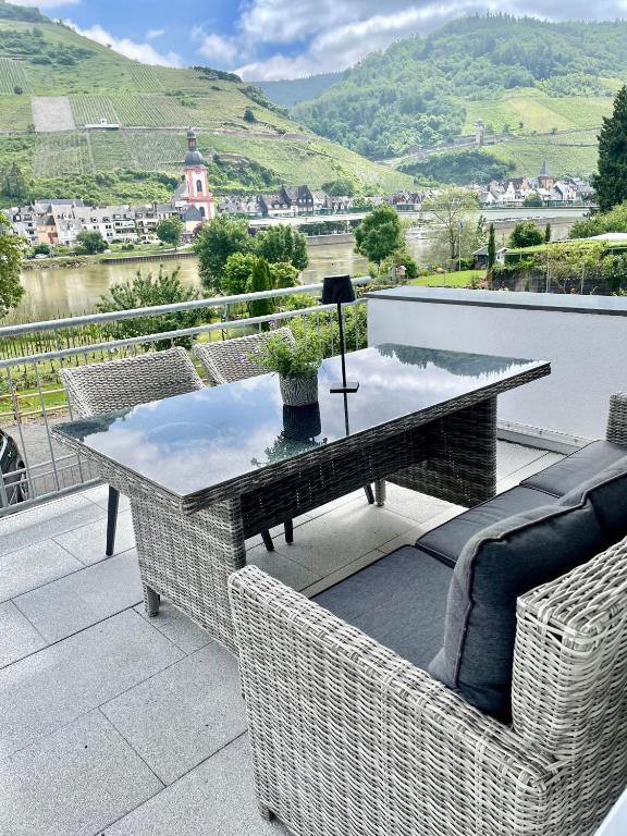 a table and chairs on a balcony with a view at DAS AMBIENTE II Komfortables Wohnerlebnis mit Moselromantik - Herzlich Willkommen - in Zell an der Mosel