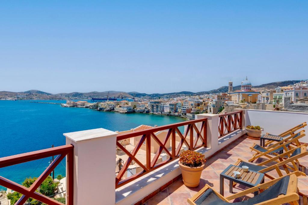 balcón con sillas y vistas al agua en Electra Syros - Adults Only, en Ermoupoli