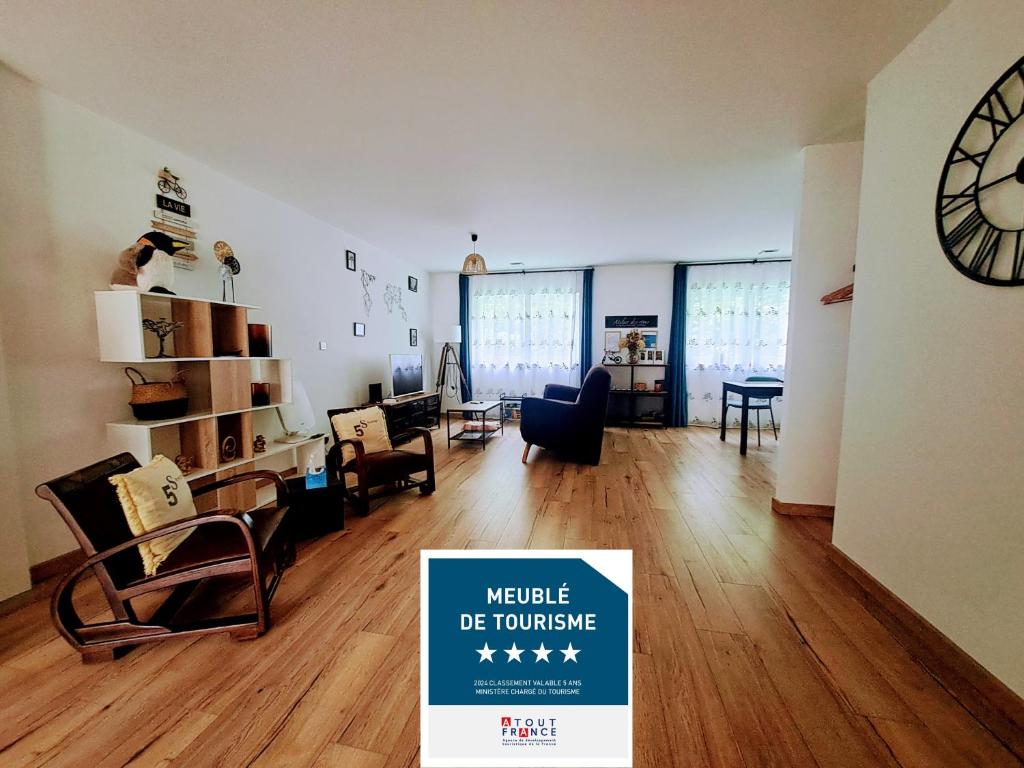 ein Wohnzimmer mit einer großen Uhr an der Wand in der Unterkunft LocBreuillet91 in Breuillet